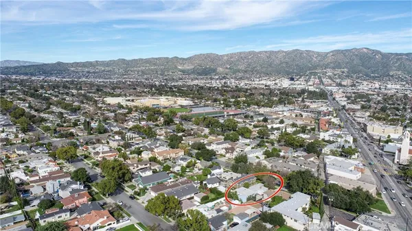 an aerial view of residential houses with outdoor space and trees