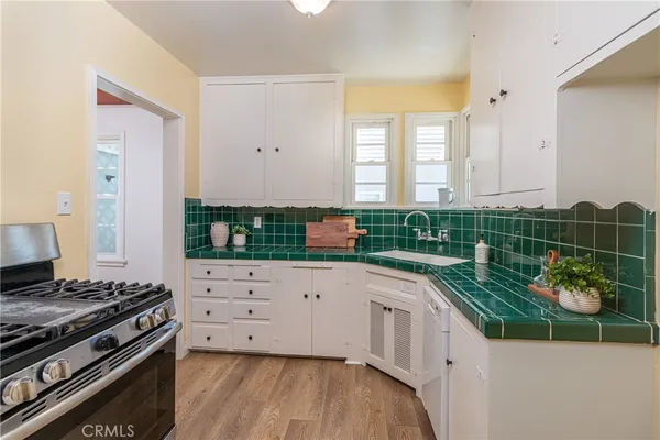 a kitchen with stainless steel appliances a stove and a wooden floor