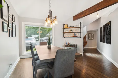 a view of a dining room with furniture a chandelier and wooden floor