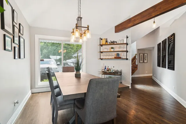 a view of a dining room with furniture a chandelier and wooden floor