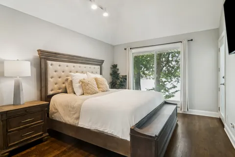 a large bed sitting in a bedroom next to a window