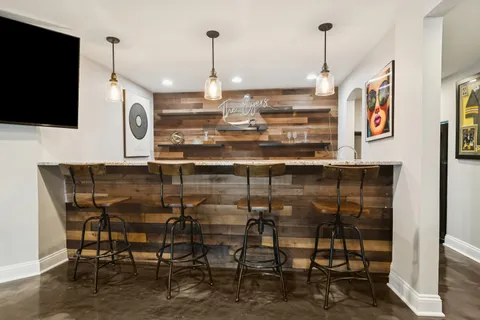 a kitchen with stainless steel appliances kitchen island granite countertop a table and chairs in it