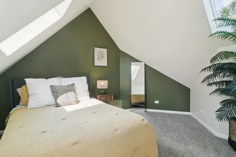 a bedroom with a large bed and a potted plant