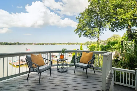 a balcony with wooden floor outdoor seating and lake view
