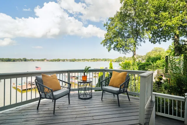 a balcony with wooden floor outdoor seating and lake view