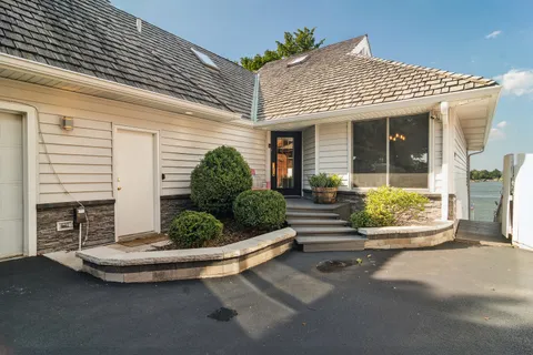 a front view of a house with a garden and plants