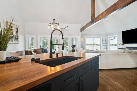 a kitchen with stainless steel appliances granite countertop a sink a stove and a wooden floor