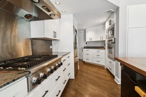 a kitchen with stainless steel appliances granite countertop a stove and a refrigerator