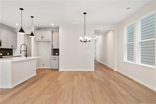 a view of a hallway with wooden floor and windows