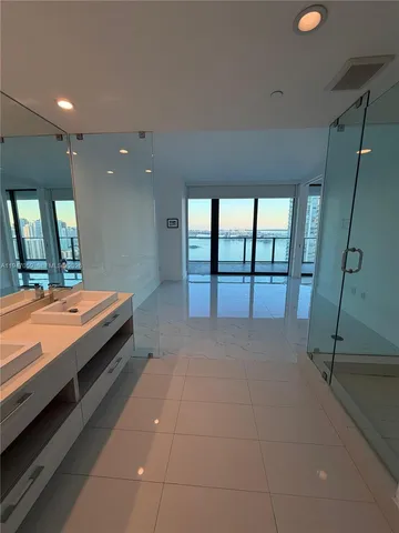 a spacious bathroom with a double vanity sink and a large mirror