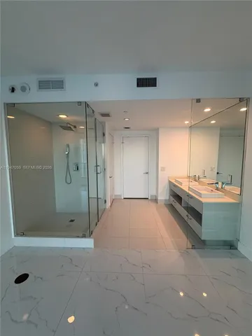 a bathroom with a double vanity sink toilet and shower