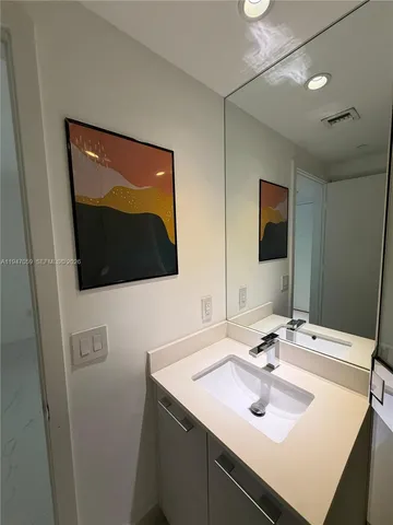 a bathroom with a shower sink mirror and toilet