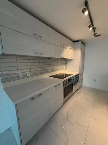 a kitchen with granite countertop a sink and stainless steel appliances