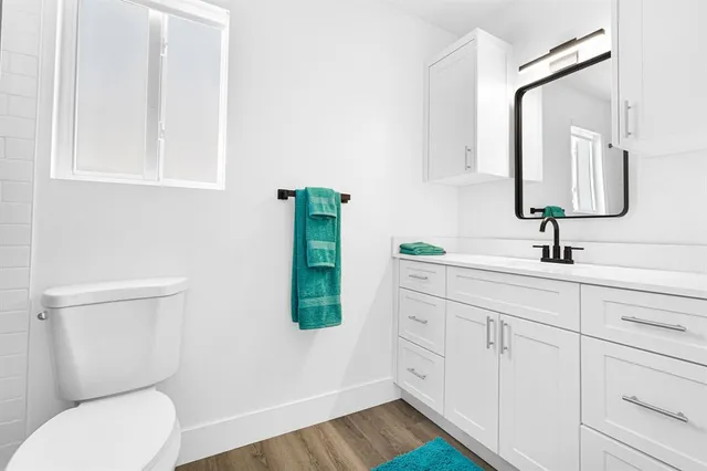 a white toilet sitting next to a bathroom sink and a shower