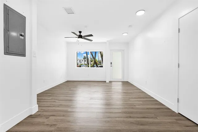 a view of a livingroom with wooden floor and a ceiling fan