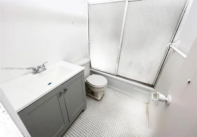a bathroom with a sink a toilet a mirror and shower