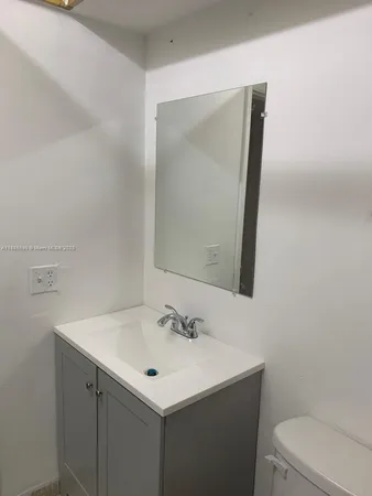 a bathroom with a sink toilet and mirror