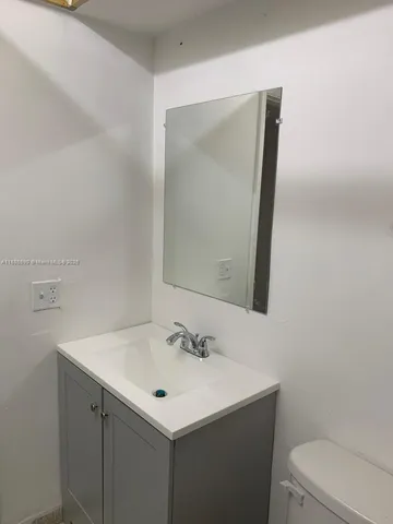 a bathroom with a sink toilet and mirror