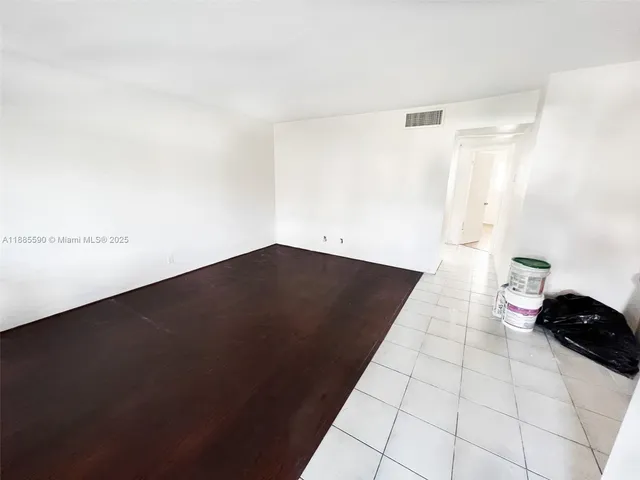 a view of an empty room and wooden floor