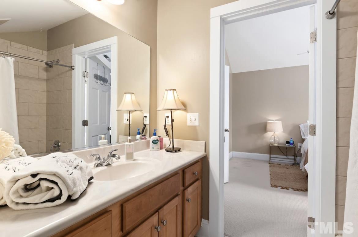 613 West Cabarrus Street, Unit 202 Raleigh, NC 27603 - Photo 11 of 17 a en suite bathroom with a sink and a mirror