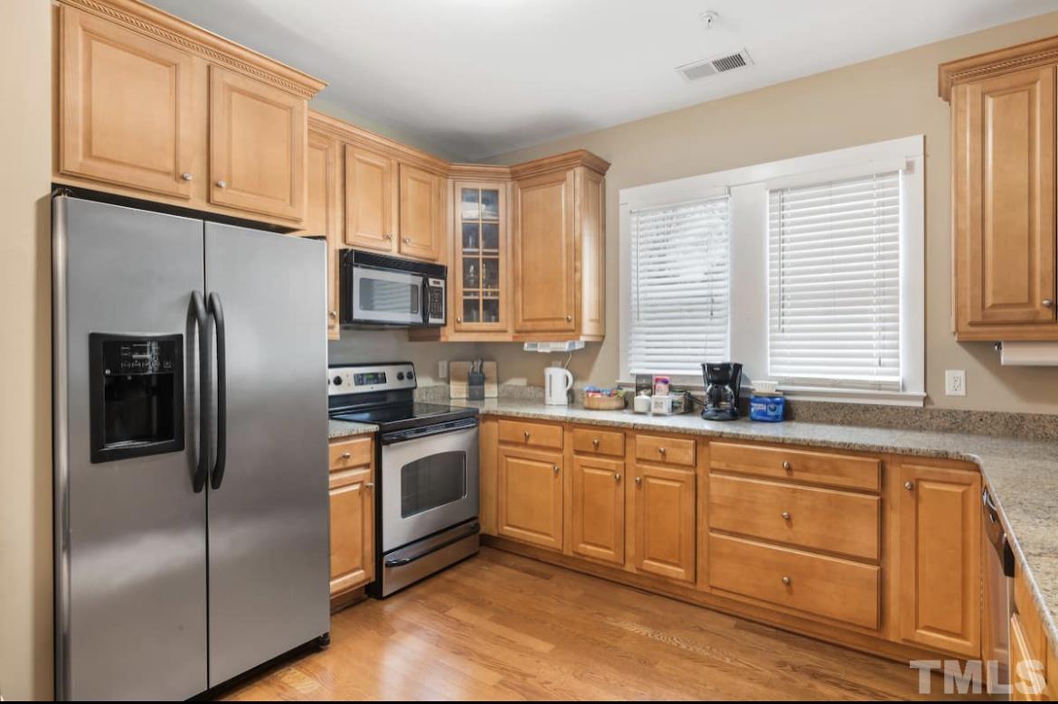 613 West Cabarrus Street, Unit 202 Raleigh, NC 27603 - Photo 14 of 17 a kitchen with stainless steel appliances granite countertop a refrigerator a stove a sink and dishwasher