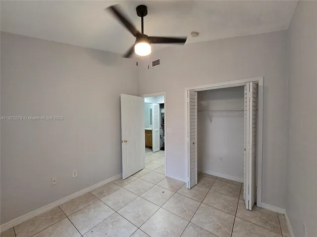 an empty room with fan and entrance