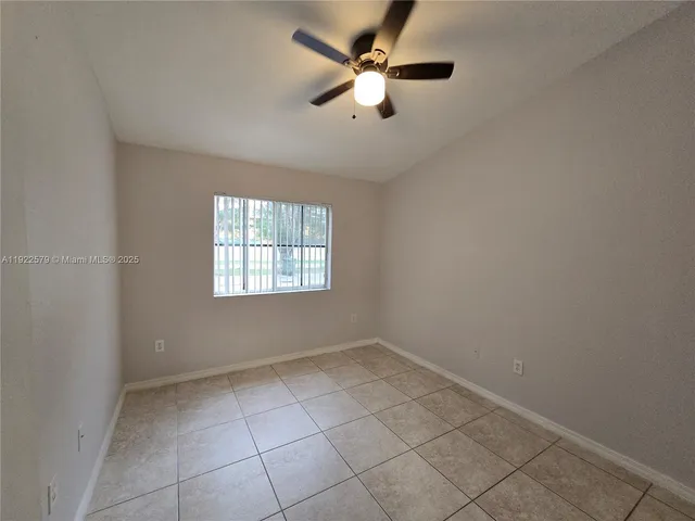 an empty room with a window and a fan