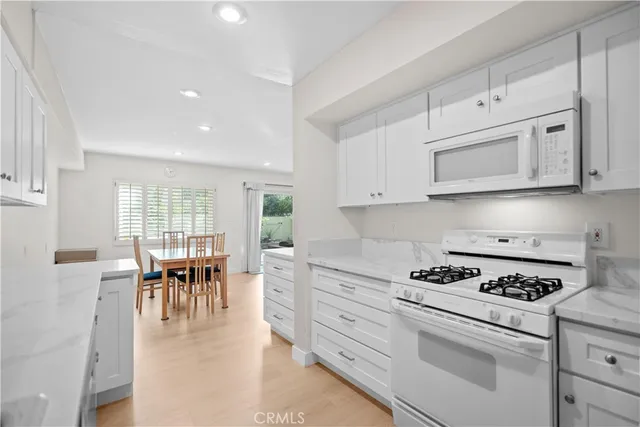 a kitchen with granite countertop cabinets and dining table chairs