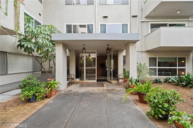 front view of a brick house with potted plants