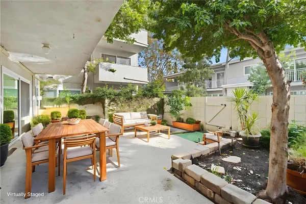 a view of a patio with table and chairs and a barbeque
