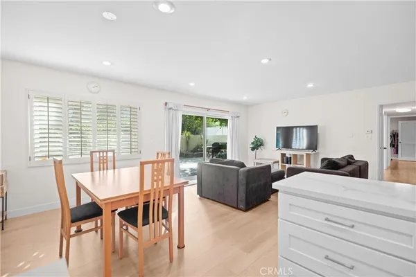 a living room with furniture a large window and a wooden floor
