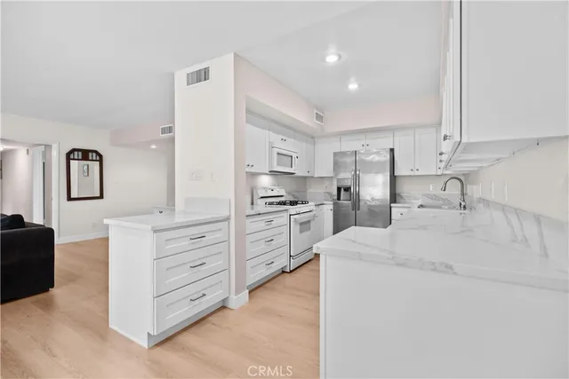 a kitchen with white cabinets and stainless steel appliances