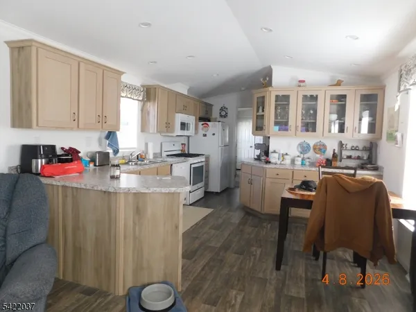 a kitchen with granite countertop a sink cabinets and wooden floor