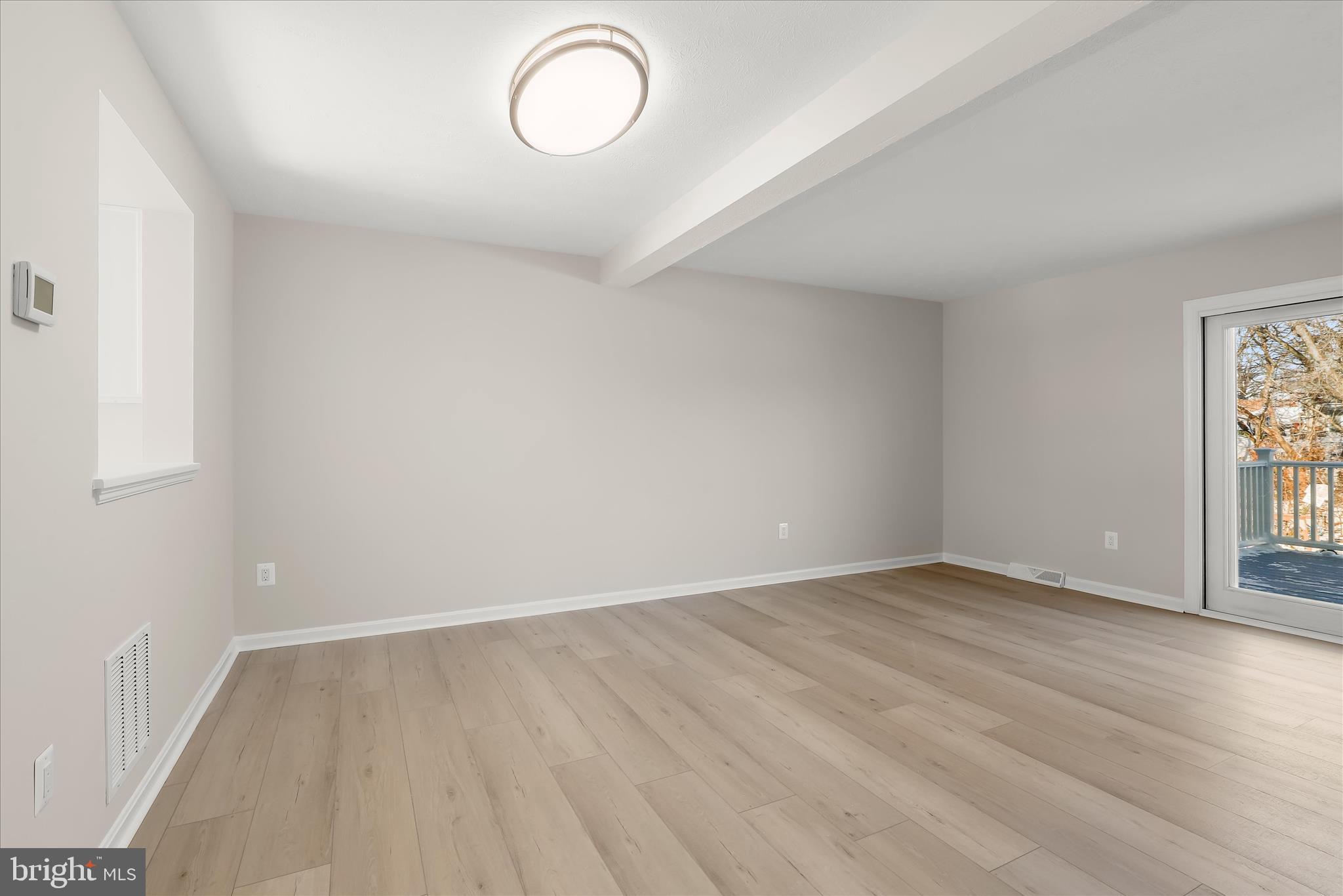 893 Century Street Hampstead, MD 21074 - Photo 9 of 42 a view of an empty room with wooden floor and a window