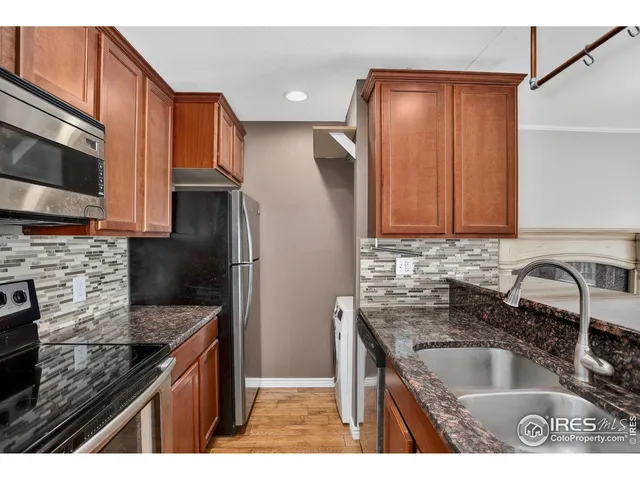 a kitchen with kitchen island granite countertop a sink stove and refrigerator