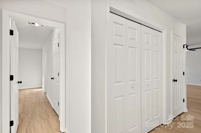 a view of a hallway with wooden floor and closet area