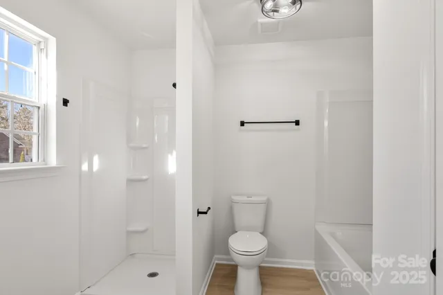 a bathroom with a shower a toilet and sink
