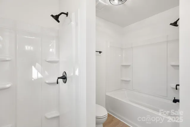 a bathroom with a shower a toilet and a shower