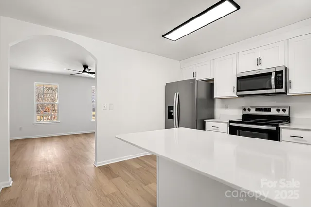 a kitchen with stainless steel appliances a refrigerator microwave and sink