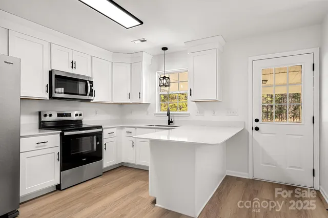 a kitchen with a sink a microwave and cabinets