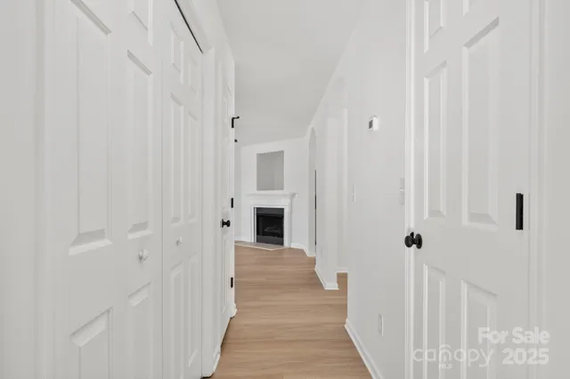a view of a hallway with wooden floor and staircase