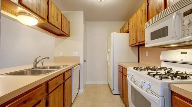 a kitchen with stainless steel appliances granite countertop a sink and a stove