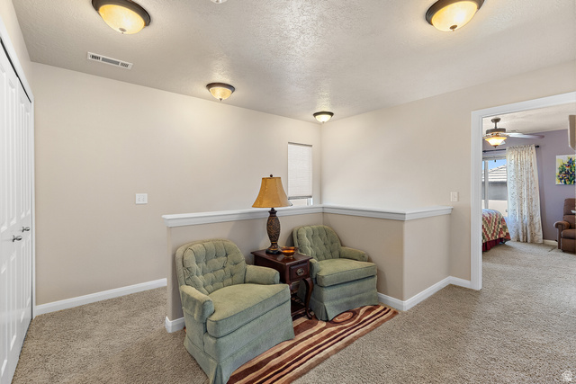 2484 Manzoni Road Santa Clara, UT 84765 - Photo 17 of 27 Living area featuring a textured ceiling, carpet, ceiling fan, and an upstairs landing