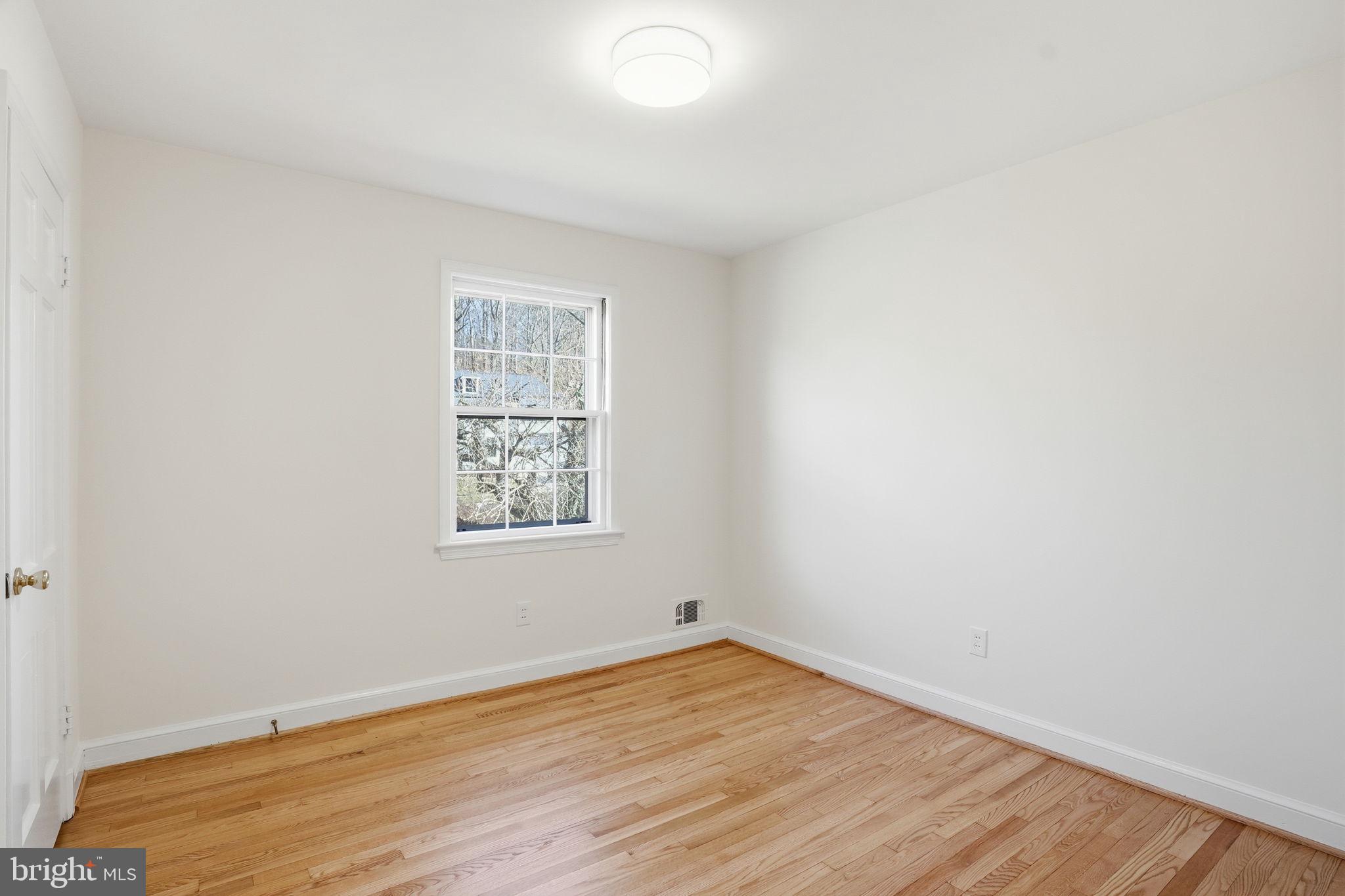 8200 Beech Tree Road Bethesda, MD 20817 - Photo 18 of 29 an empty room with wooden floor and windows