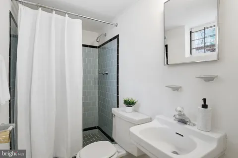a bathroom with a sink a toilet and shower curtain