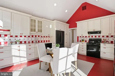 a kitchen with stainless steel appliances kitchen island granite countertop a refrigerator stove microwave and white cabinets