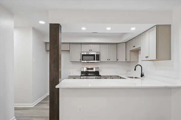 a kitchen with stainless steel appliances granite countertop a sink a stove a refrigerator a microwave and cabinets