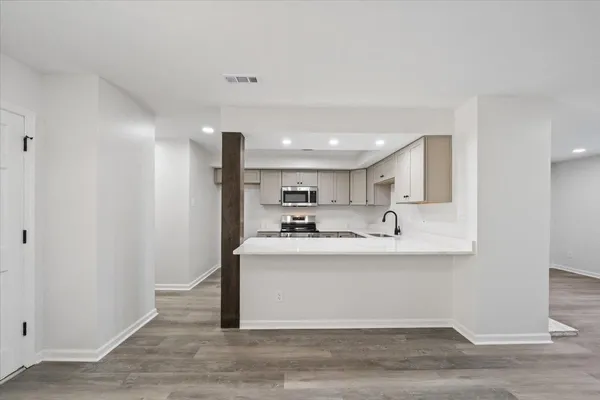a view of kitchen with stainless steel appliances granite countertop refrigerator sink and stove