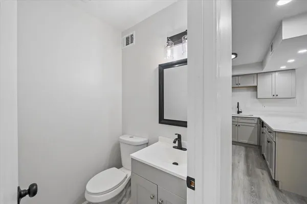 a bathroom with a toilet a sink and mirror
