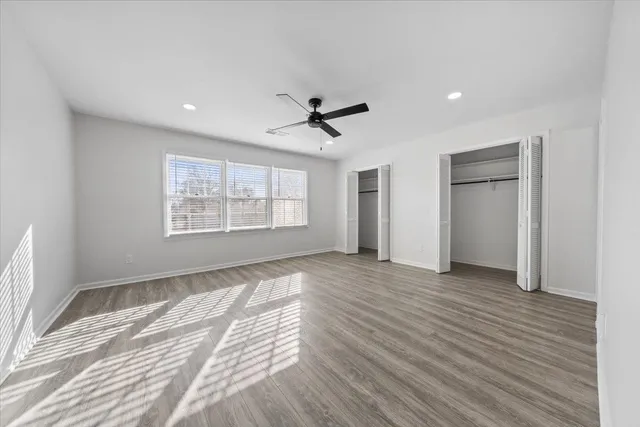 a view of an empty room with a window and a kitchen
